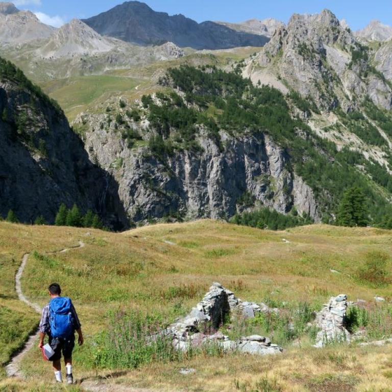 Un uomo che cammina su colline rocciose verso il Lago Nero
