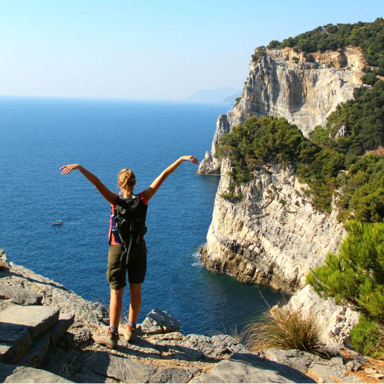 Woman standing on a rock observing Mediterrean