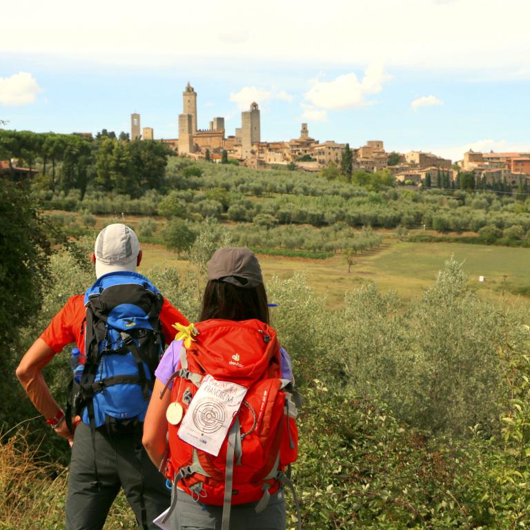 woman and man standing in front of san gimignano