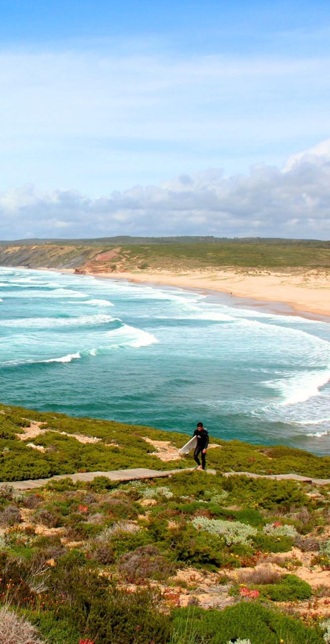 surfer walking on the beach of the portuguese coast