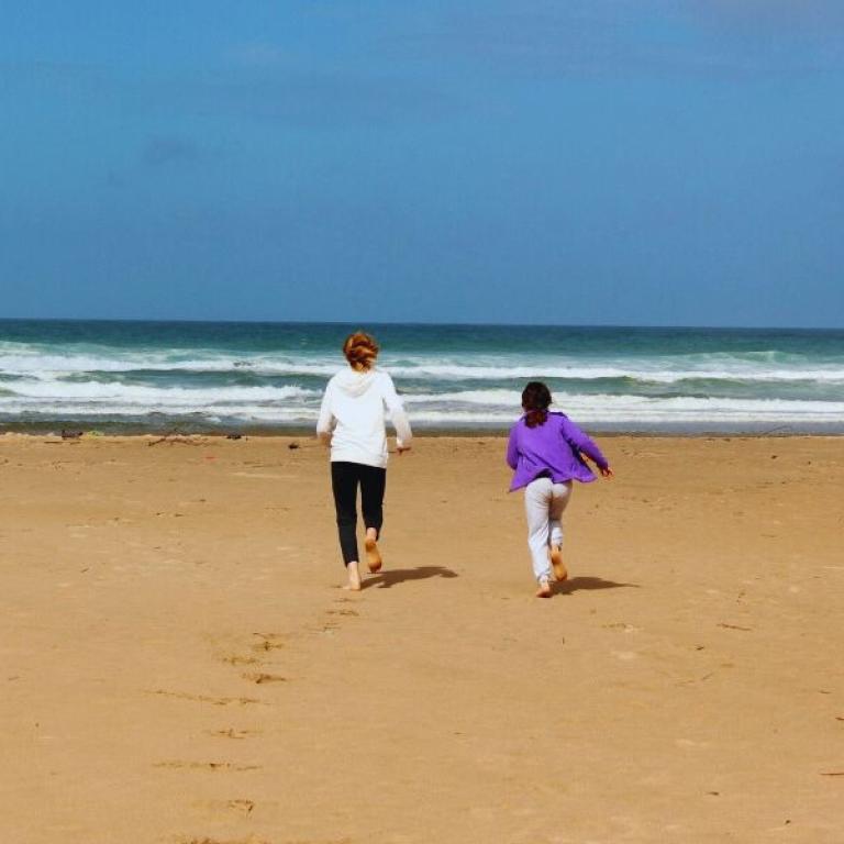 women walking rota vicentina and running to the sea