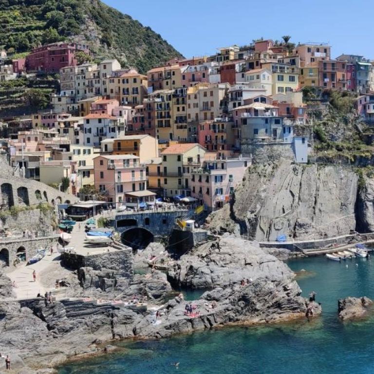 Manarola village clinging to rocky cliffs, with colorful houses overlooking the sea in the heart of Cinque Terre