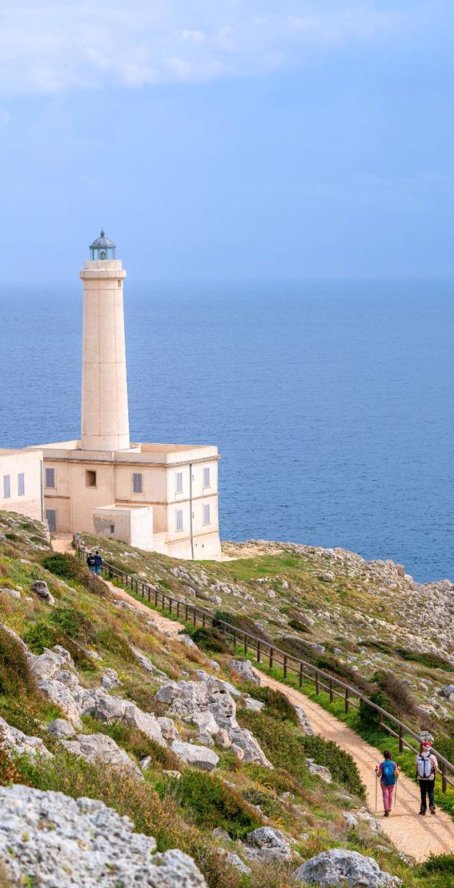 Hikers walking along the coastal path of the Via della Costa Salentina with a view of the blue sea
