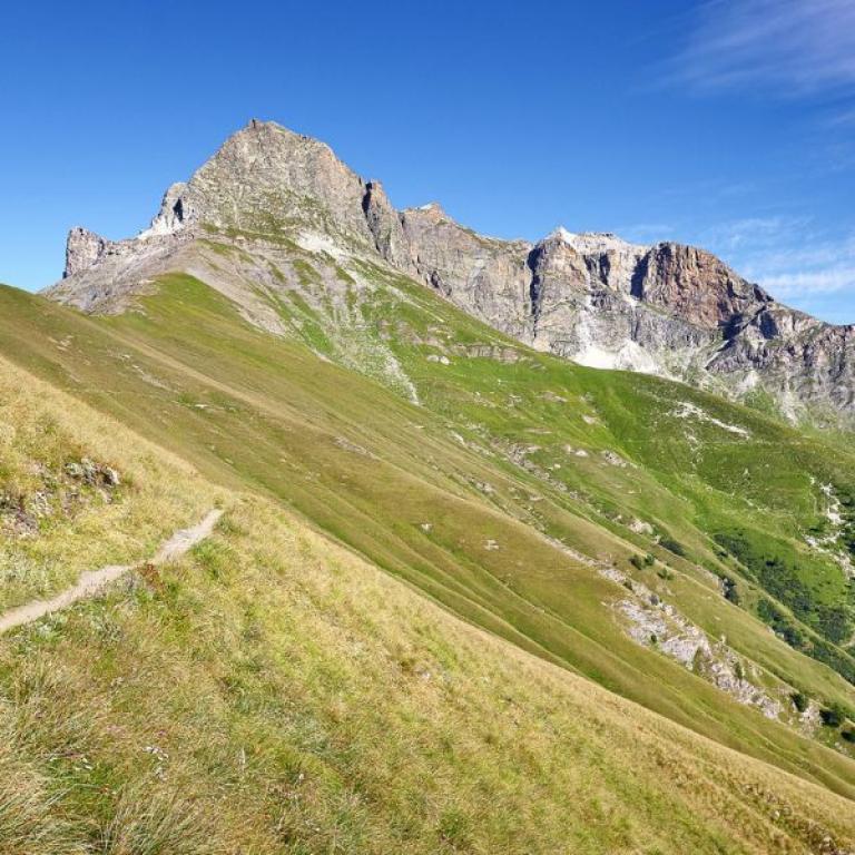 escursionista che percorre un sentiero nella Valle Maira, una valle alpina in provincia di Cuneo, in Piemonte.