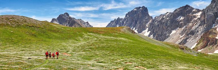 Camminatori lungo un sentiero della Val Maira in Piemonte durante un trekking