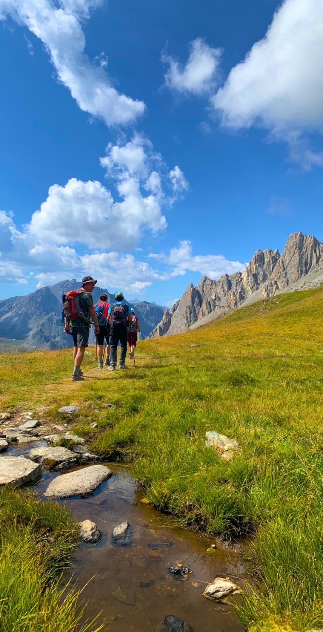 Camminatori lungo un sentiero della Val Maira in Piemonte durante un trekking