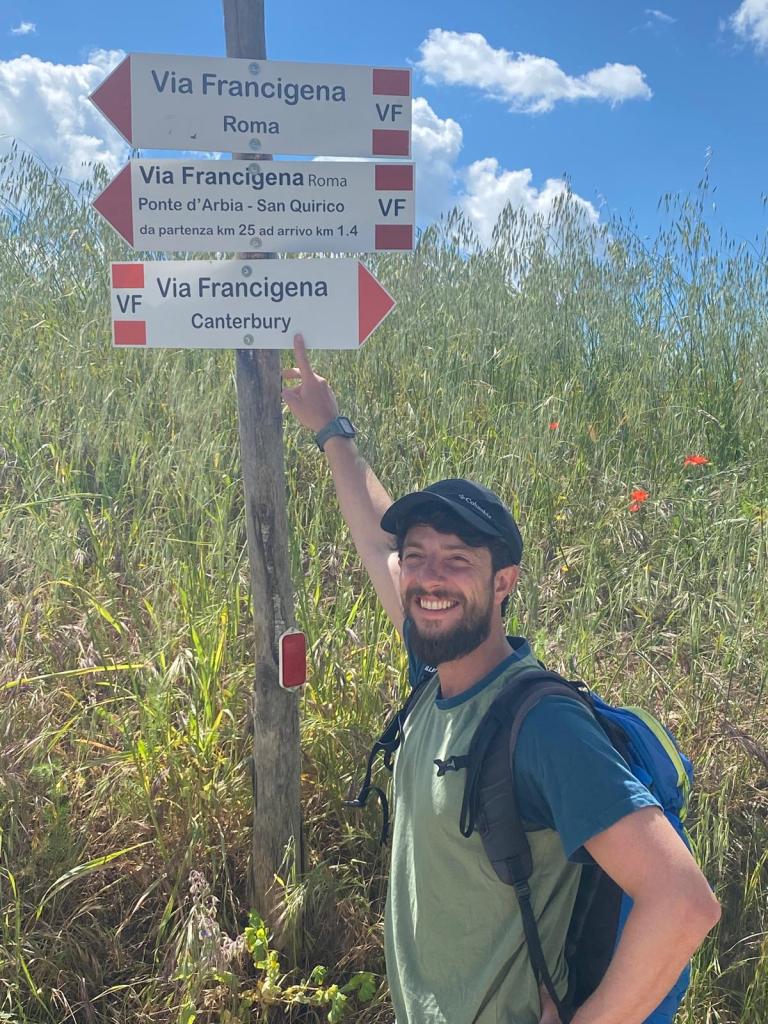 Two people walking on a Via Francigena countryside path