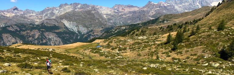 A man walks atop mountains on the Via Francigena