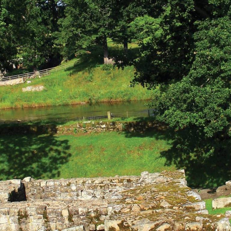 Rovine del forte romano lungo Hadrian’s Wall – resti in pietra dell’antico forte con muro in mezzo a campi