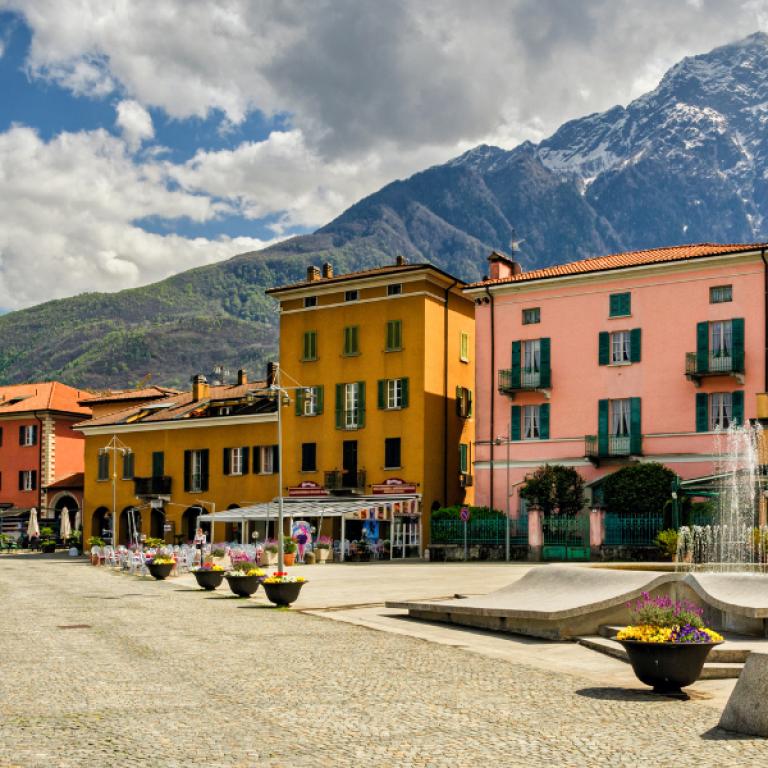 Historic square in Colico framed by alpine peaks, a typical village to visit while hiking Lake Como