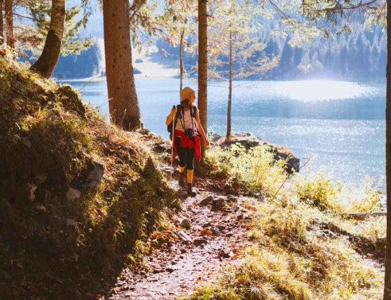 A person walks on a path near the lake