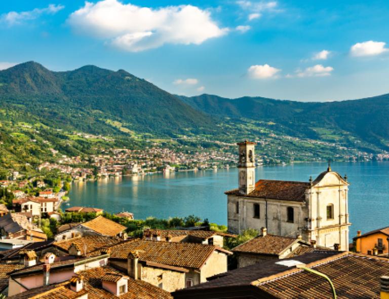 Quiet village on the shores of Lake Iseo surrounded by green hills, part of the Italian Lakes hiking region