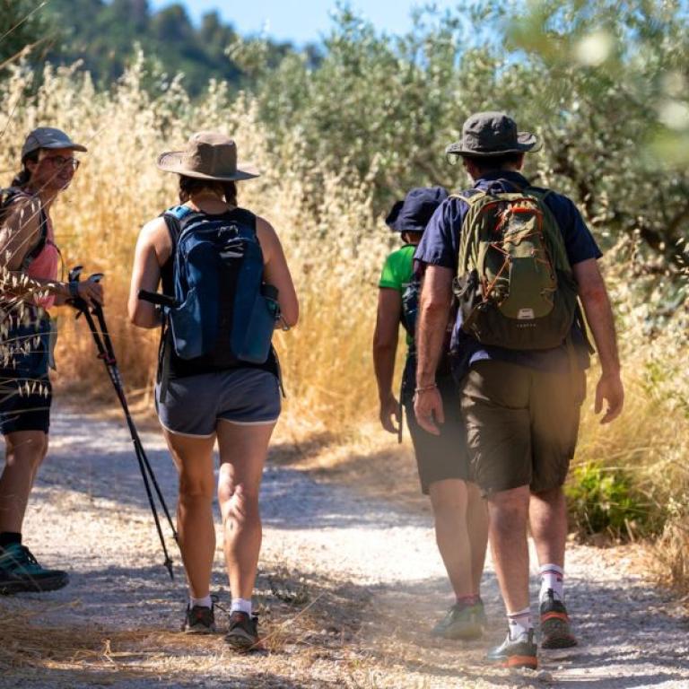 Group of hikers walking along a countryside trail during the St Francis pilgrimage easy version in Italy