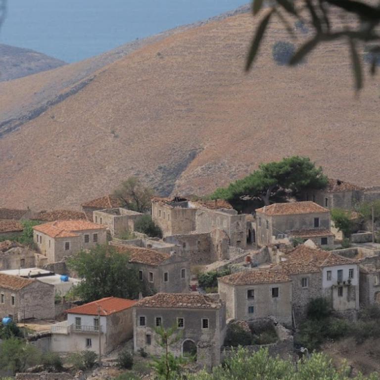 Historic hilltop village with stone houses and terraced hills on the Albania Coastal trail.