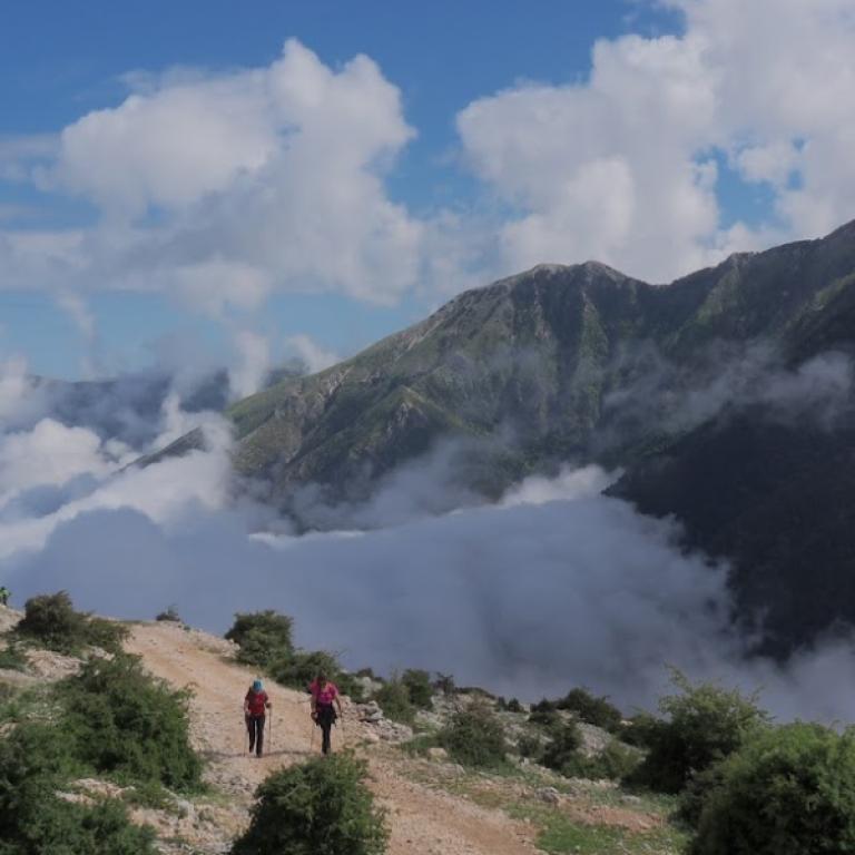 walk in hazy valley albaniaMountain valley shrouded in mist and rugged peaks along the Albania Coastal trail.