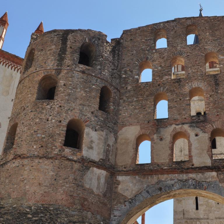 Ancient Roman gate and adjoining white church in Susa, the starting point of the trek